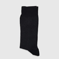A folded black men's micro modal sock with a subtle diagonal pattern, showcasing its soft texture and ribbed cuff.