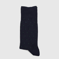 A single pair of men's navy green micro modal socks, featuring green polka dots, neatly folded and displayed flat.