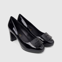 A pair of black patent leather Morbido ladies dress court shoes with block heels and square textured buckles, displayed on a