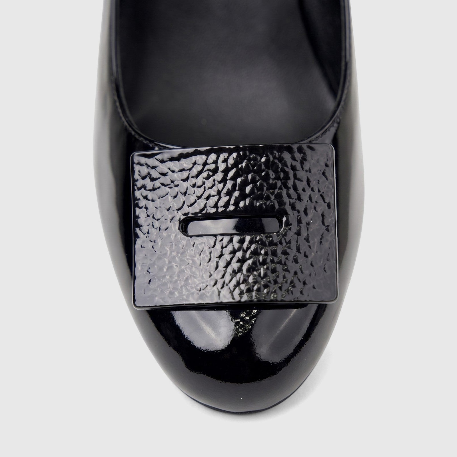 Close-up of a black patent leather Morbido ladies' dress court shoe with a rectangular textured buckle.