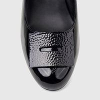 Close-up of a black patent leather Morbido ladies' dress court shoe with a rectangular textured buckle.