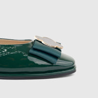 Close-up of a Morbido ladies' pump in dark green patent leather, featuring a decorative bow and gold-toned hardware on the
