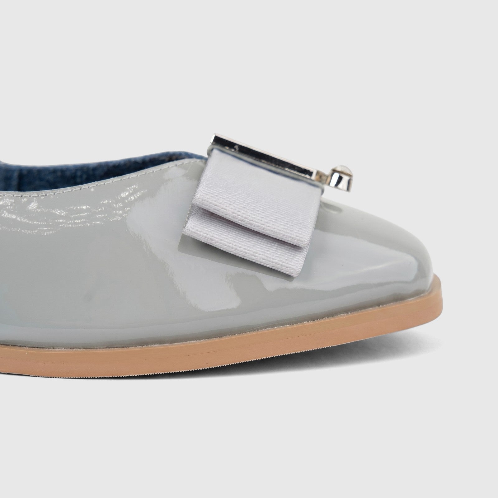 Close-up of a Morbido Ladies Leather Pump BIL-021 in light grey patent leather with a decorative bow and silver accent.
