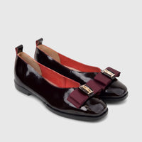 Pair of Morbido Ladies Leather Pumps in wine red patent leather, featuring decorative maroon bows and gold buckles.