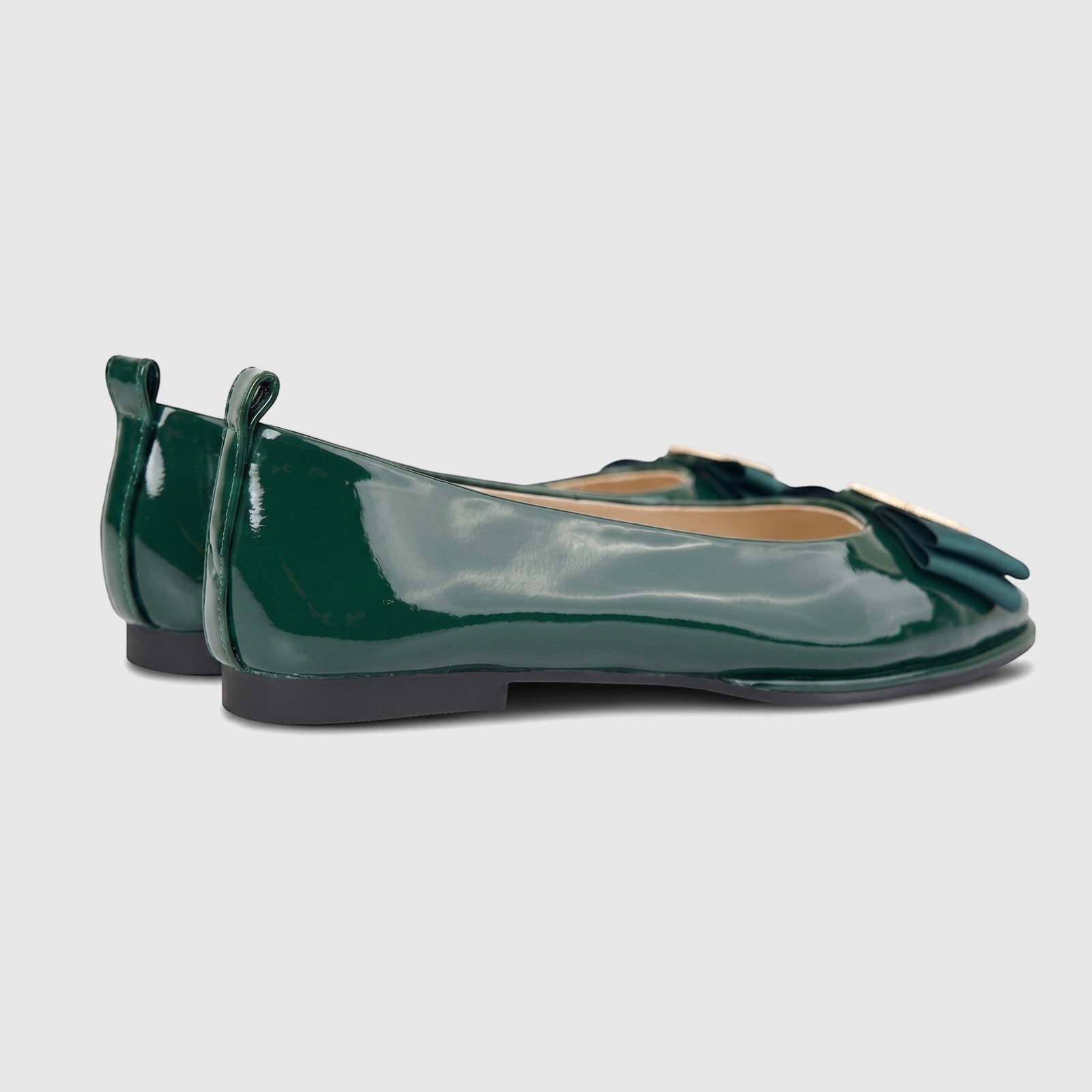 Side view of dark green patent leather Morbido Ladies Leather Pumps with a decorative bow and gold-tone buckle.