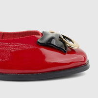 Morbido Ladies Leather Pump in dark red patent leather with a decorative black and gold buckle, captured in a close-up shot.