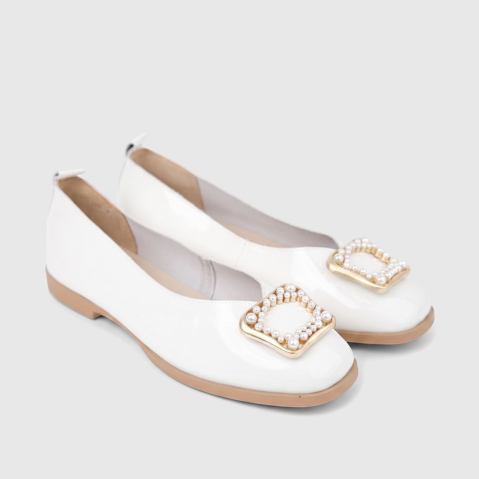 White patent leather Morbido Ladies Leather Pumps with gold and pearl square buckles, viewed from an elevated angle.