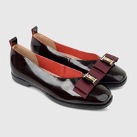 Morbido Ladies Leather Pumps in wine red patent leather, featuring elegant maroon bows with gold-toned hardware, viewed from