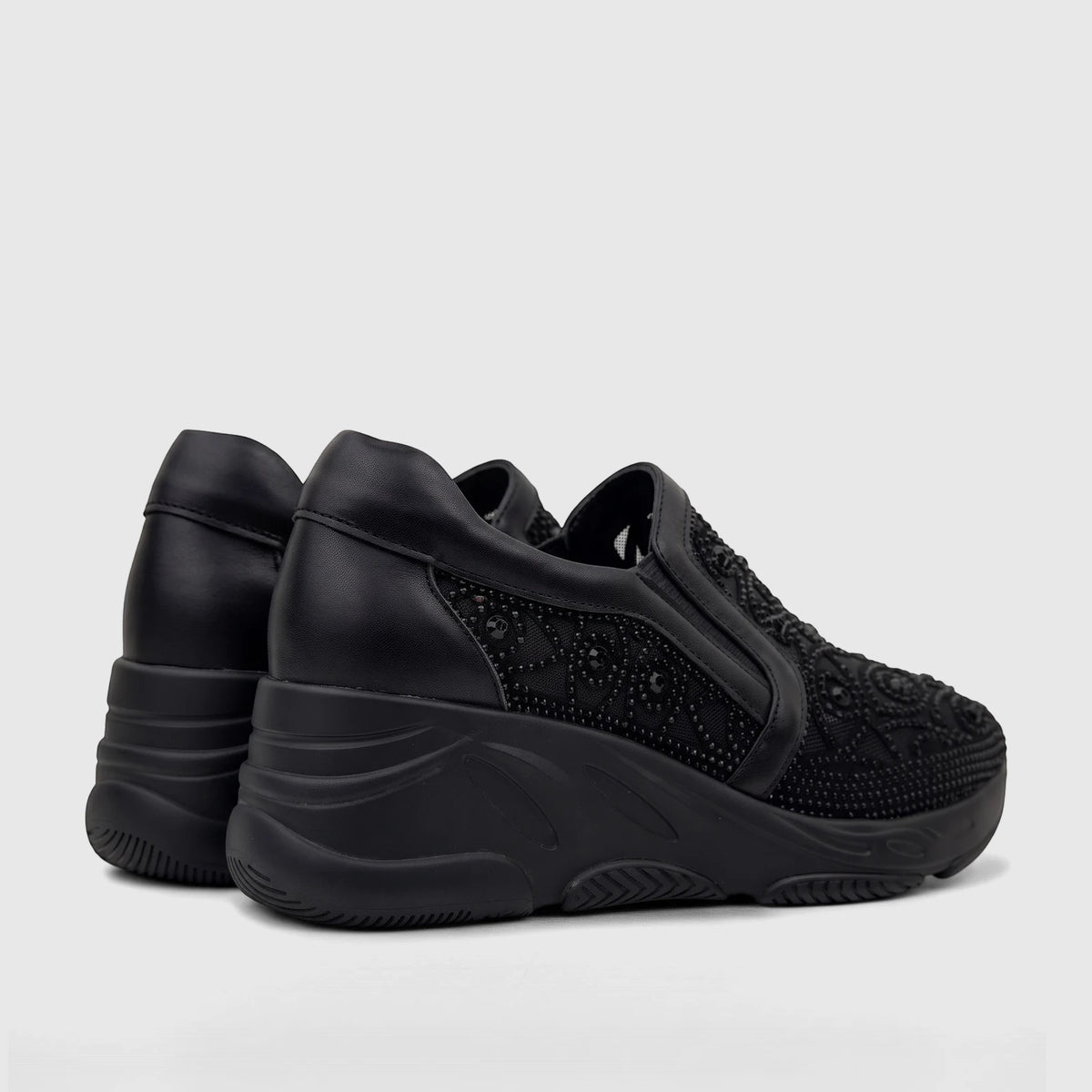 Pair of black Morbido ladies leather slip-on sneakers with embellished uppers and chunky platform soles, viewed from the