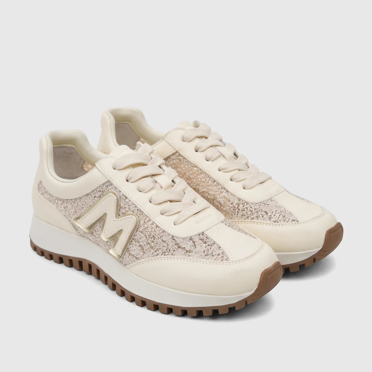 Beige Morbido ladies leather sneakers with glitter panels and a gold 'M' logo, shown paired on a white surface.
