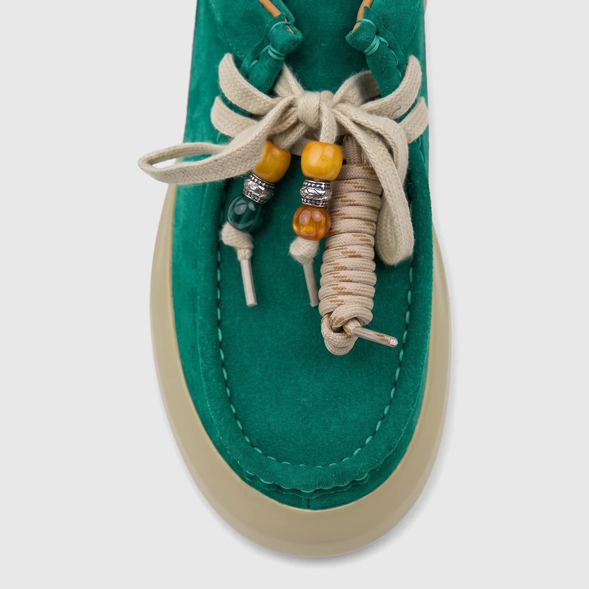 Close-up top view of a Morbido Ladies Leather Sneaker HAS-001 in green suede with decorative beige laces and colorful beads.