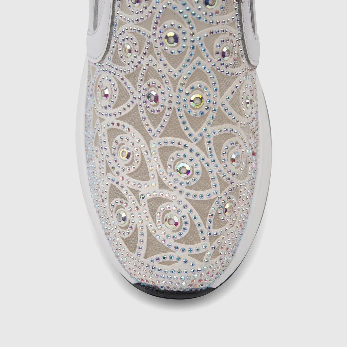 Close-up of a white Morbido Ladies Leather Sneaker with iridescent rhinestones in an intricate pattern on the upper, showing