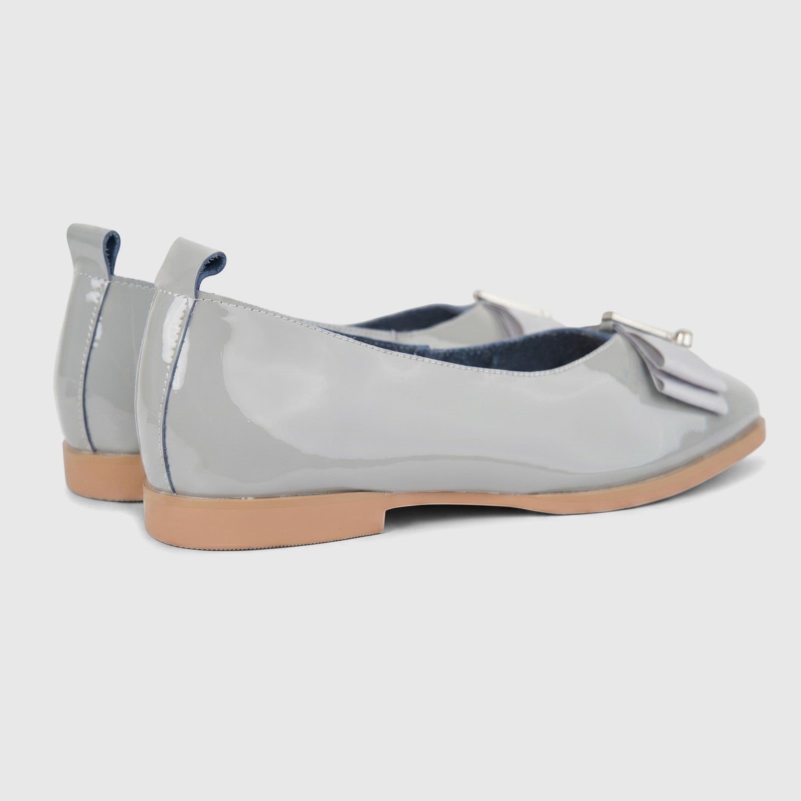 Morbido Ladies Leather Pumps in light grey patent leather, featuring a decorative bow, viewed from the rear-side angle.
