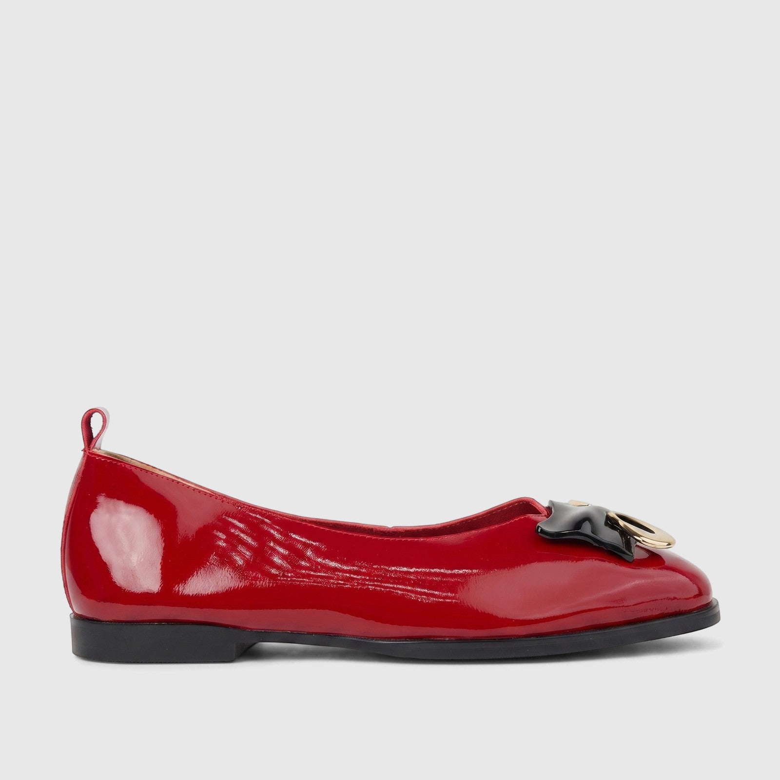 Morbido Ladies red patent leather ballet flat shoe in a side profile, featuring a black bow and gold ring detail on the vamp.