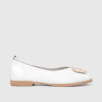 White patent leather ladies' flat shoe with a pearl and gold embellishment, featuring a tan sole, side view.