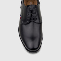 Black boys' dress lace-up shoe with a small flag logo on the side, presented on a clear stand.
