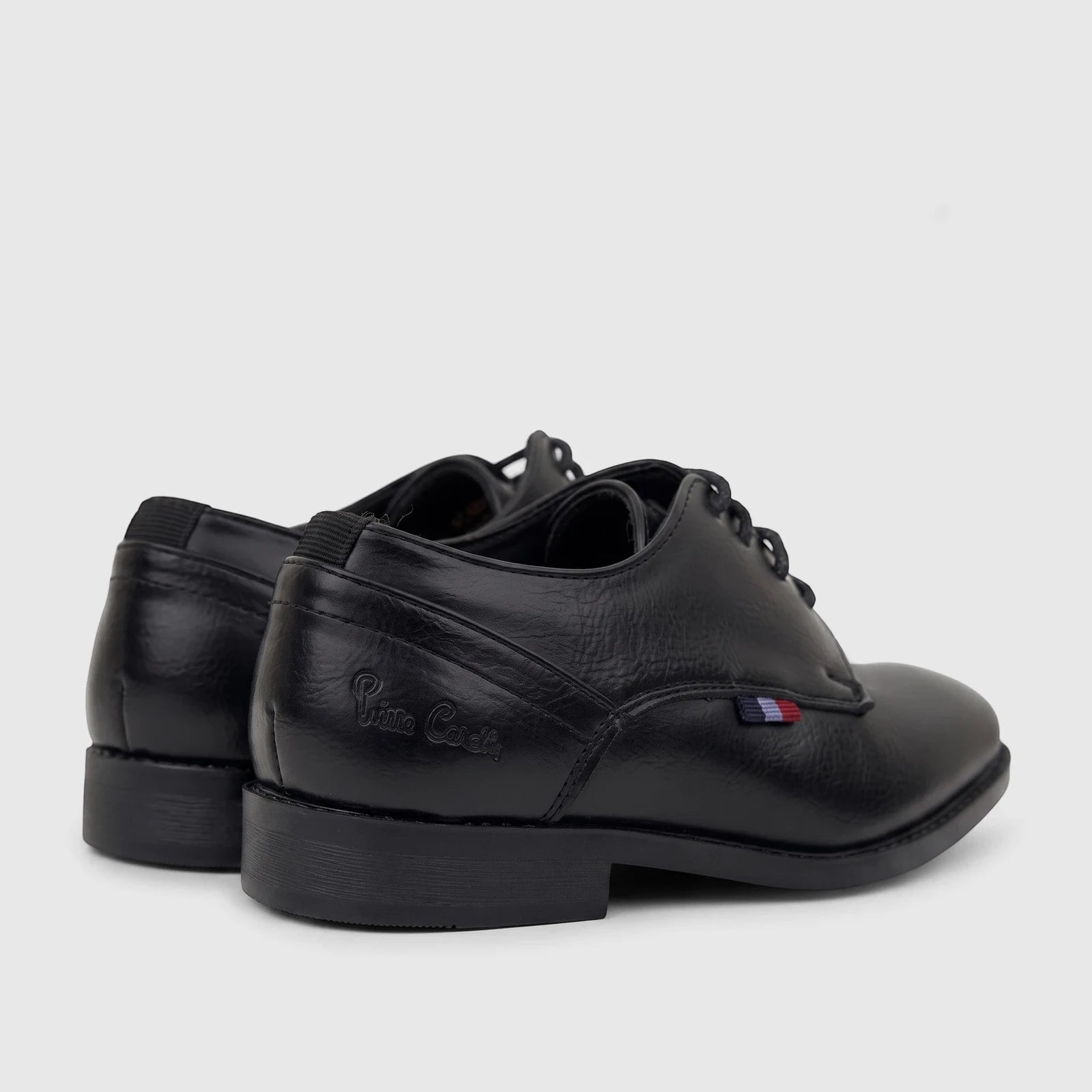 Pair of black PC Boys dress lace-up shoes, featuring 'Pierre Cardin' branding and a small red, white, and blue tag.