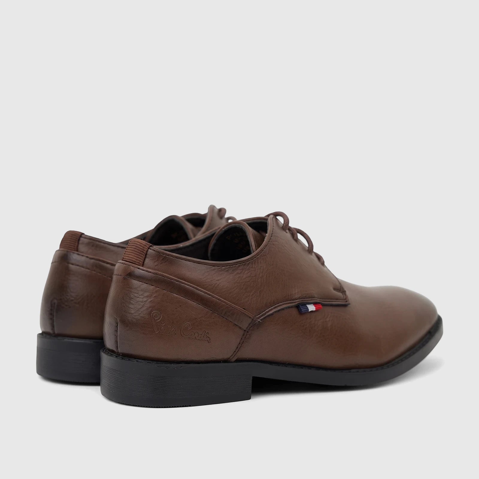 A pair of brown PC Boys dress lace-up shoes with black soles and brown laces, viewed from a slightly angled perspective.