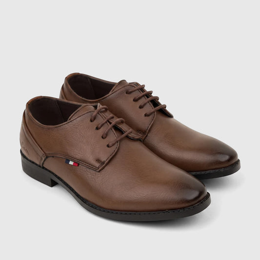 Brown PC Boys dress lace-up shoe with a classic design, black sole, and a subtle red, white, and blue stripe detail.