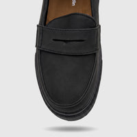 Close-up view of a single PC Boys Youth black casual slip-on loafer shoe, showing its textured faux leather material and
