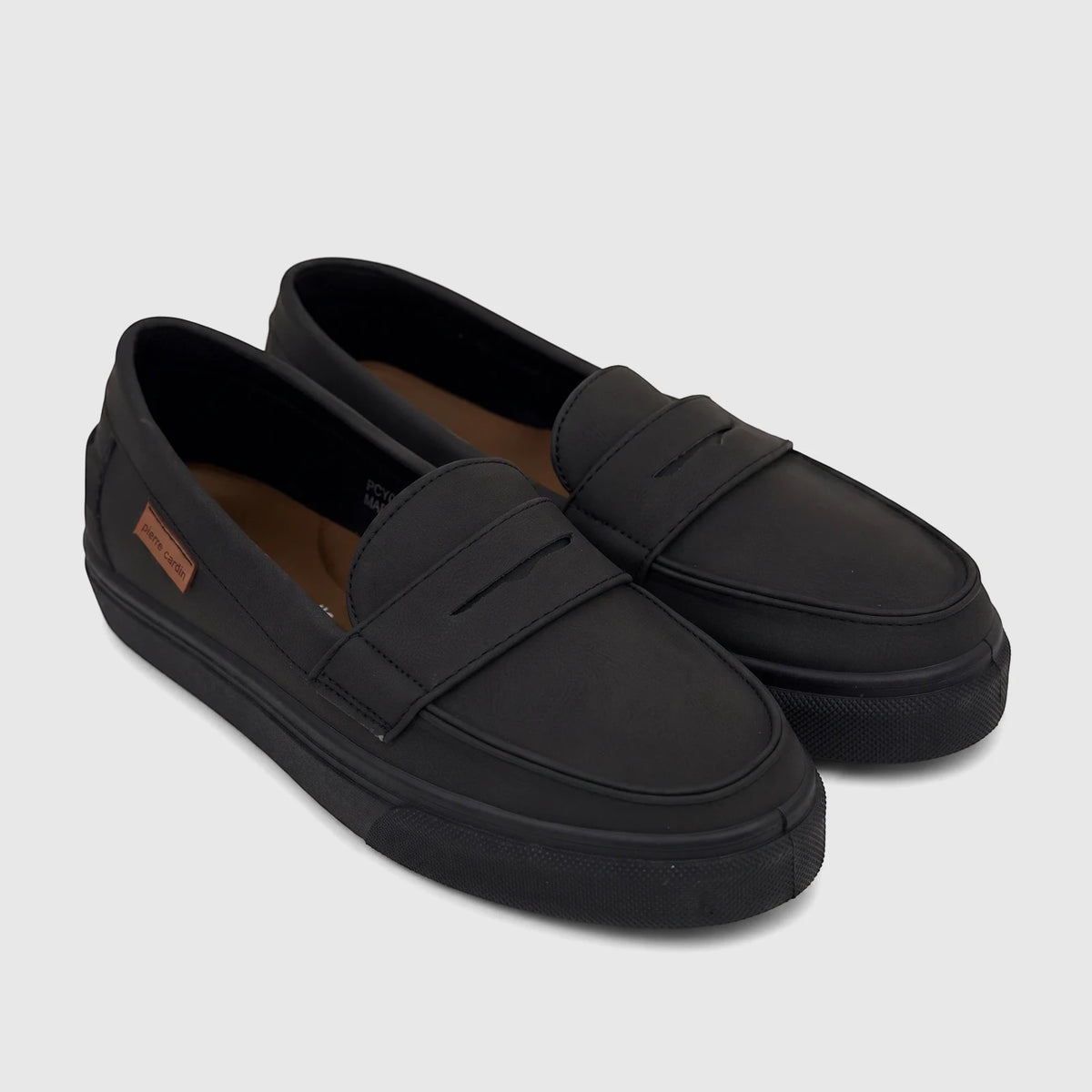 Pair of black casual slip-on shoes for youth, featuring a loafer-style design and smooth matte finish, angled view.