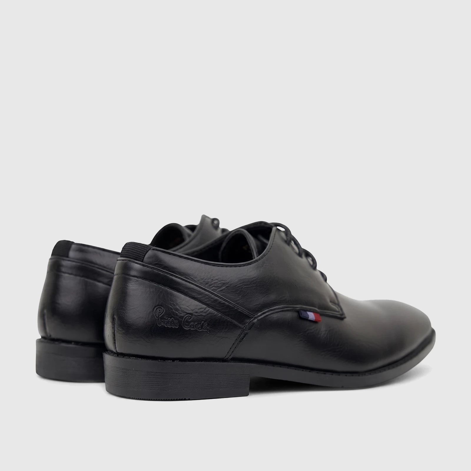 Black faux leather lace-up dress shoes for boys, with an embossed logo and striped detail, viewed from a rear-side angle.