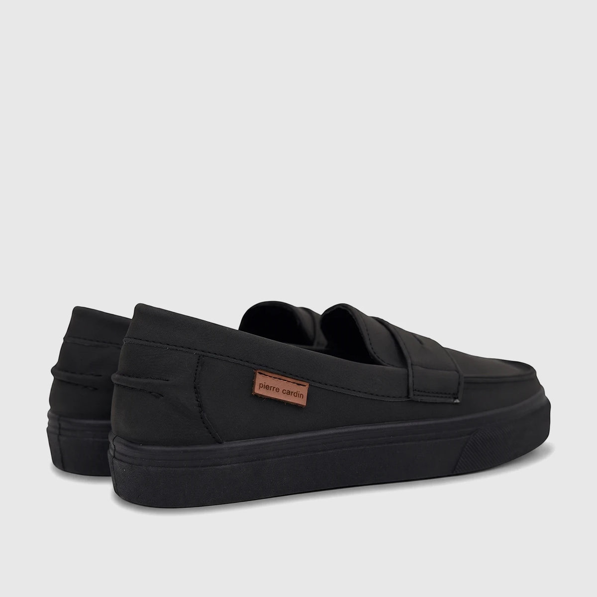 Black Pierre Cardin casual slip-on shoes for boys youth, featuring a flat sole and a brand tag on the side.