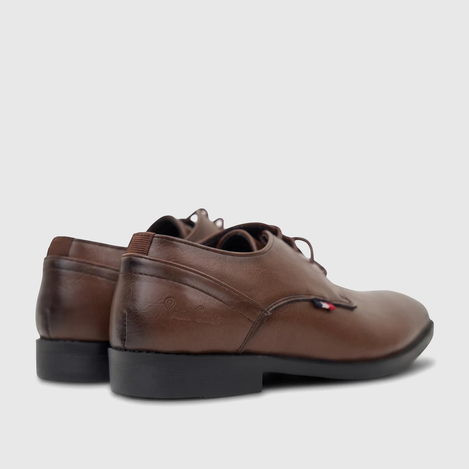 A pair of brown boys' youth dress lace-up shoes, with a side and rear view highlighting their design and details.