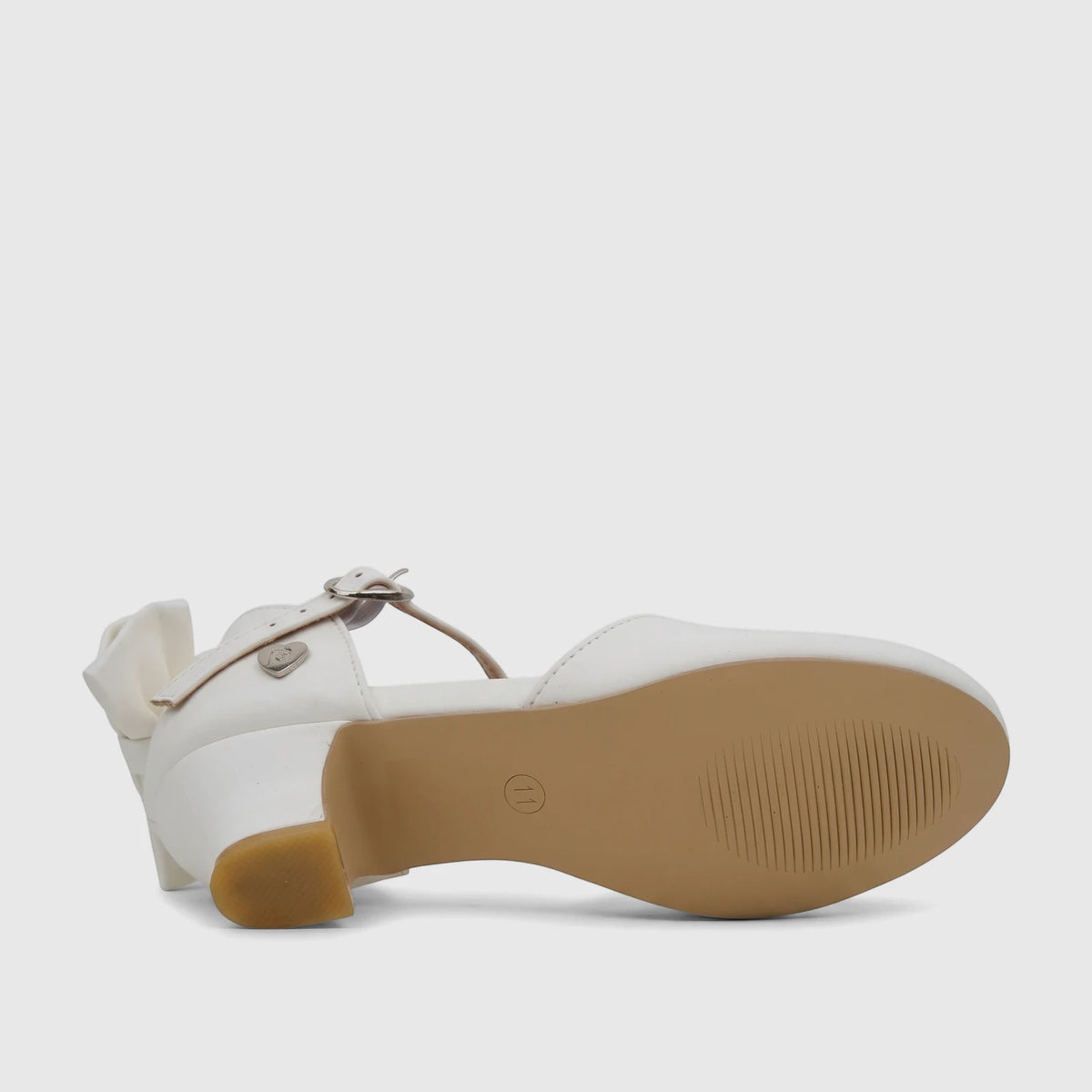 White girls' dress heel with an ankle strap and bow detail, featuring a block heel and tan sole, viewed from the side.
