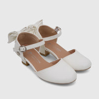 A pair of white PC Girls Dress Heels with elegant bows and ankle straps, featuring a comfortable low block heel.