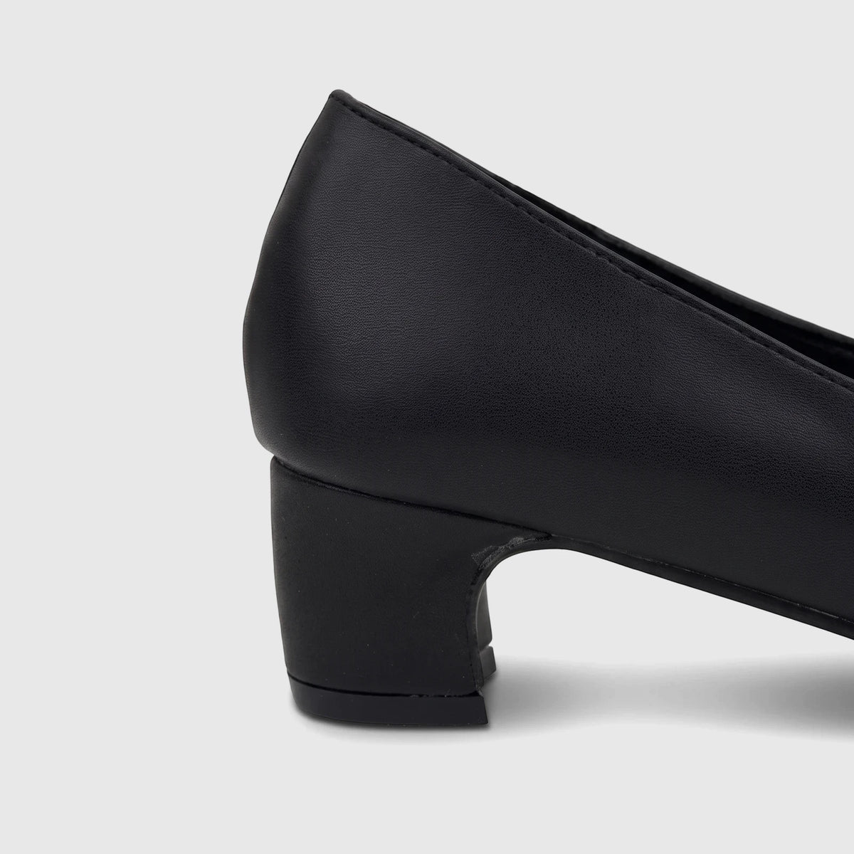 Close-up of a PC Ladies black leather dress court shoe with a block heel, visible from the side and back.