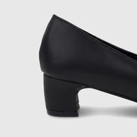 Close-up of a PC Ladies black leather dress court shoe with a block heel, visible from the side and back.