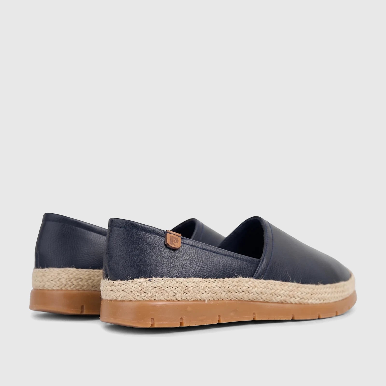 Pair of navy blue women's espadrille loafers with braided jute soles and tan outsoles, seen from a rear-side view.
