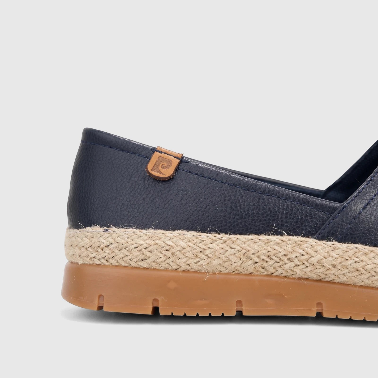 Close-up of a navy blue casual espadrille loafer with a braided jute midsole and tan rubber sole.