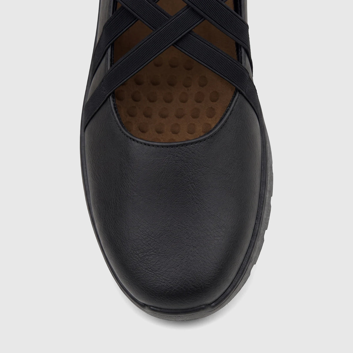 Close-up top view of a black PC Ladies Casual Pump featuring criss-cross elastic straps and a textured sole.