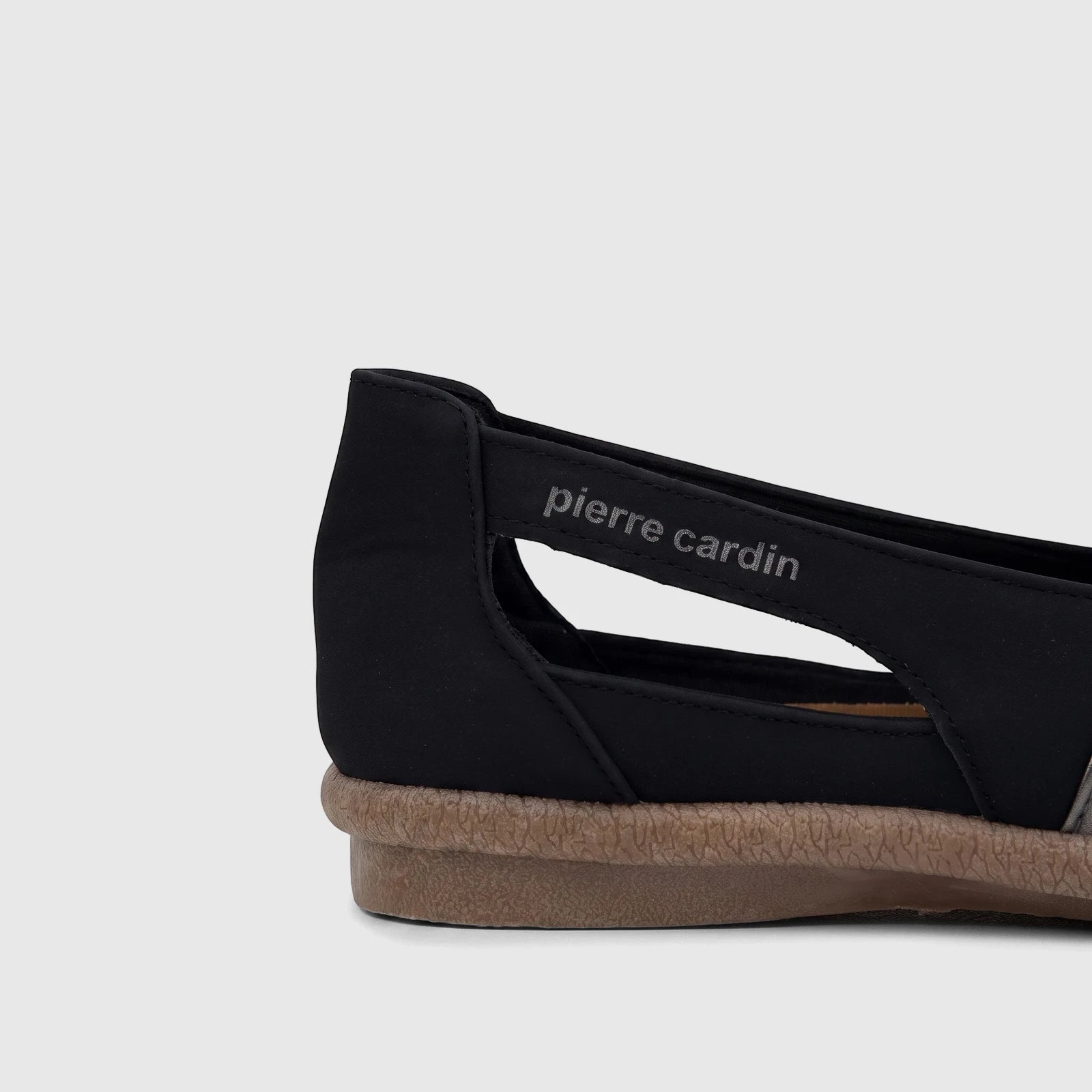 Side view of a black Pierre Cardin ladies' casual pump with a silver metallic strap and a textured beige sole.