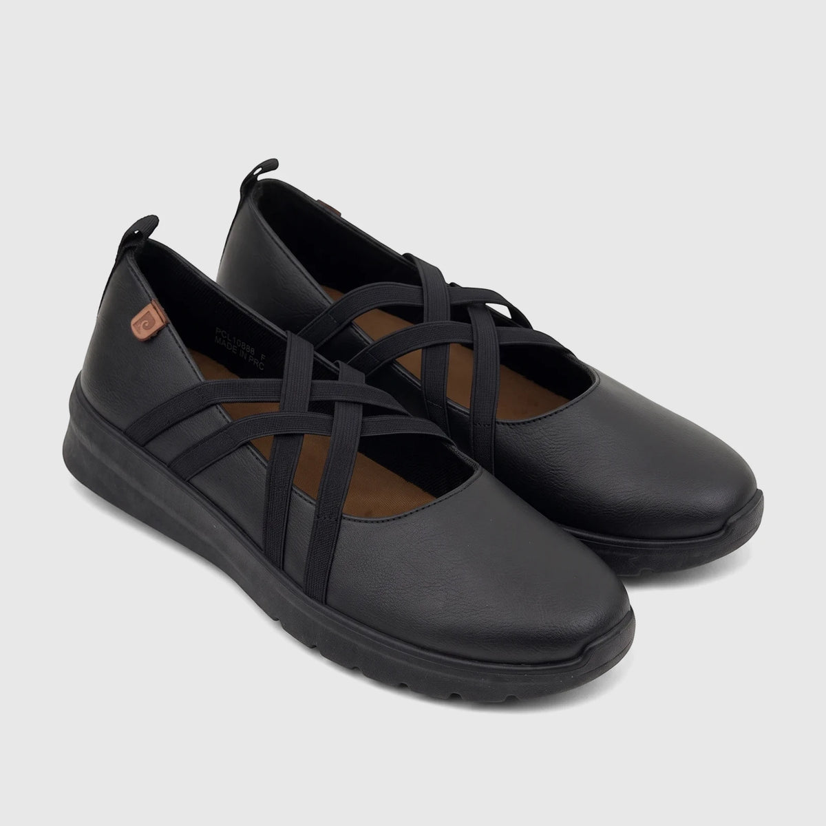 Pair of black PC Ladies Casual Pump shoes with criss-cross elastic straps, featuring a flat sole and matte finish.