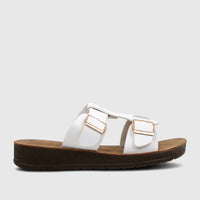White PC Ladies Casual Sandal with gold buckles and a textured dark brown platform sole, shown from the side.