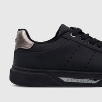 Close-up of a black Pierre Cardin ladies casual sneaker with metallic silver heel detail and black laces, side view.