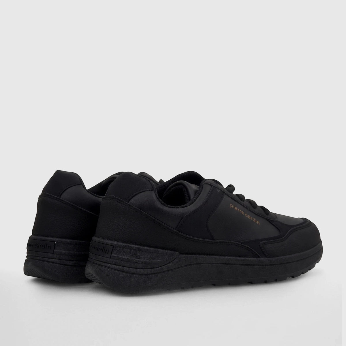 A pair of black Pierre Cardin PCL10987 casual sneakers, viewed from the back-side, featuring the brand name in gold text.