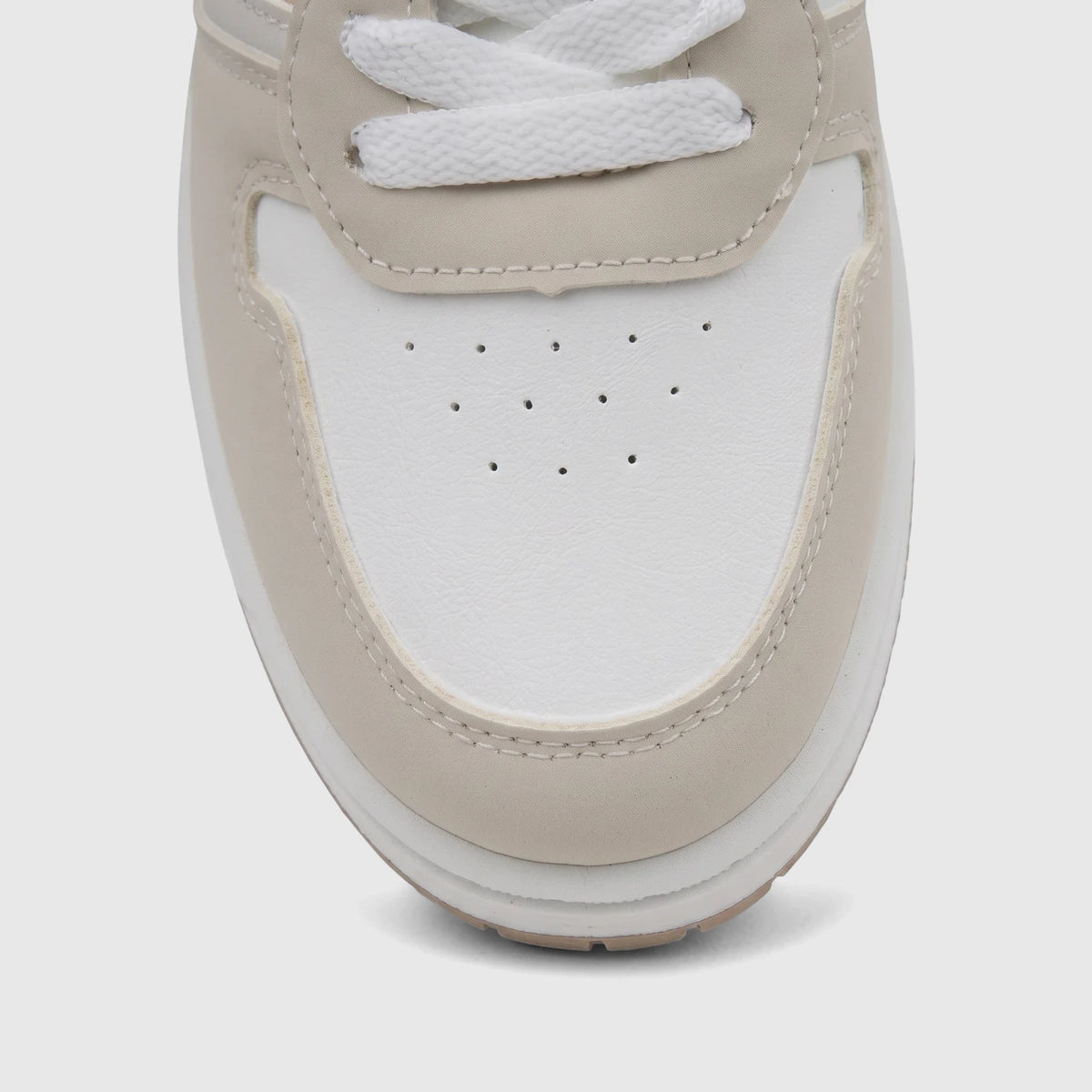 Close-up of a PC Ladies Casual Sneaker in white and beige, showing the toe box and laces from a top-down view.