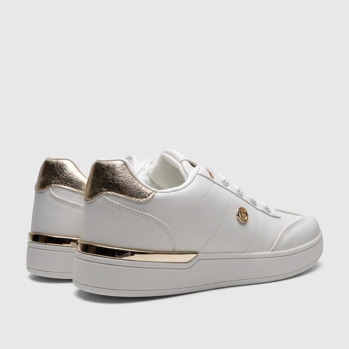 A pair of white PC Ladies Casual Sneakers with gold metallic heel accents and side logo, viewed from a low, rear-side angle.