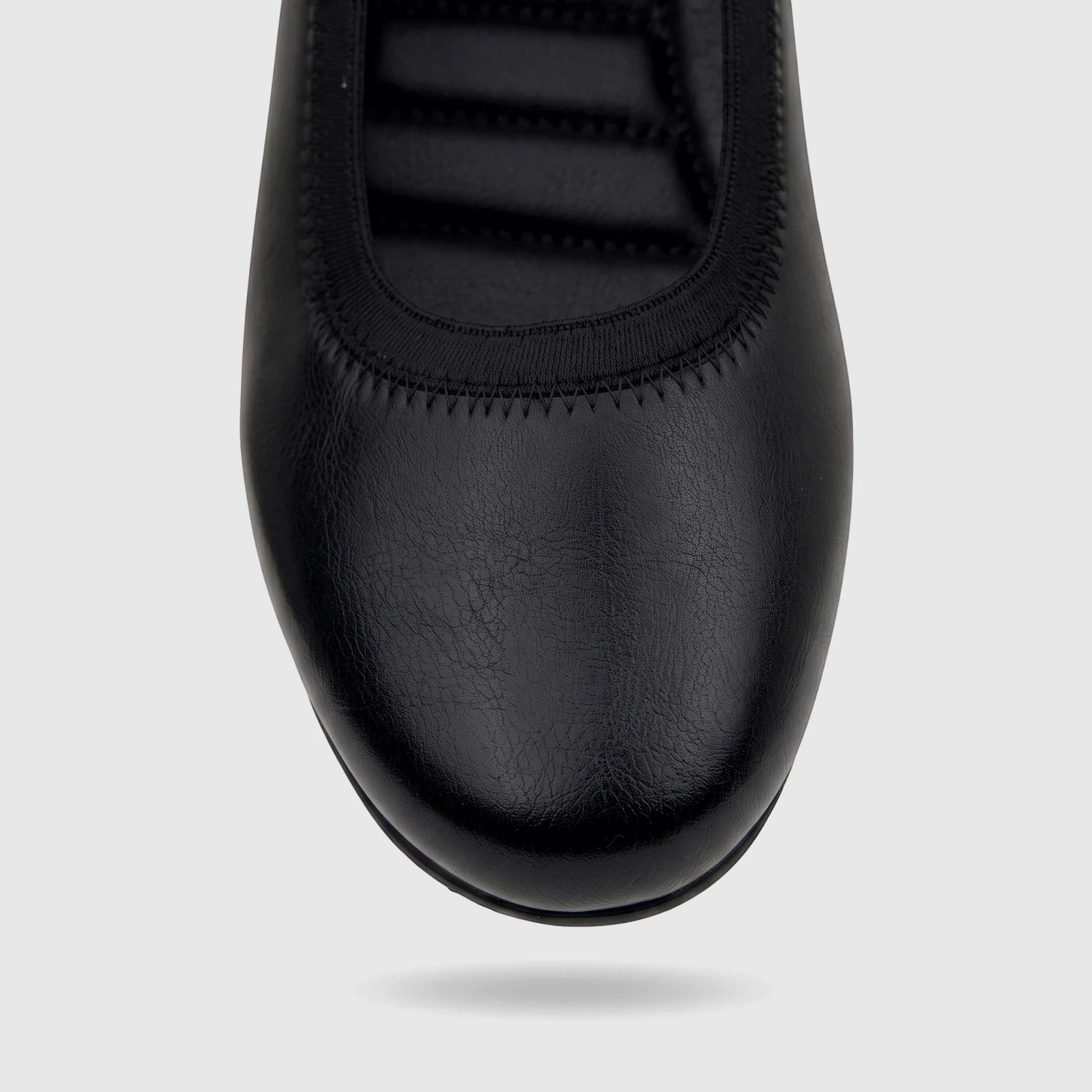 Close-up top-down view of a black PC Ladies Comfort Pump shoe made of faux leather, featuring an elasticized opening and
