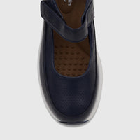 Navy blue women's comfort pump shoe with perforated toe details and an adjustable instep strap, shown in a close-up top view.