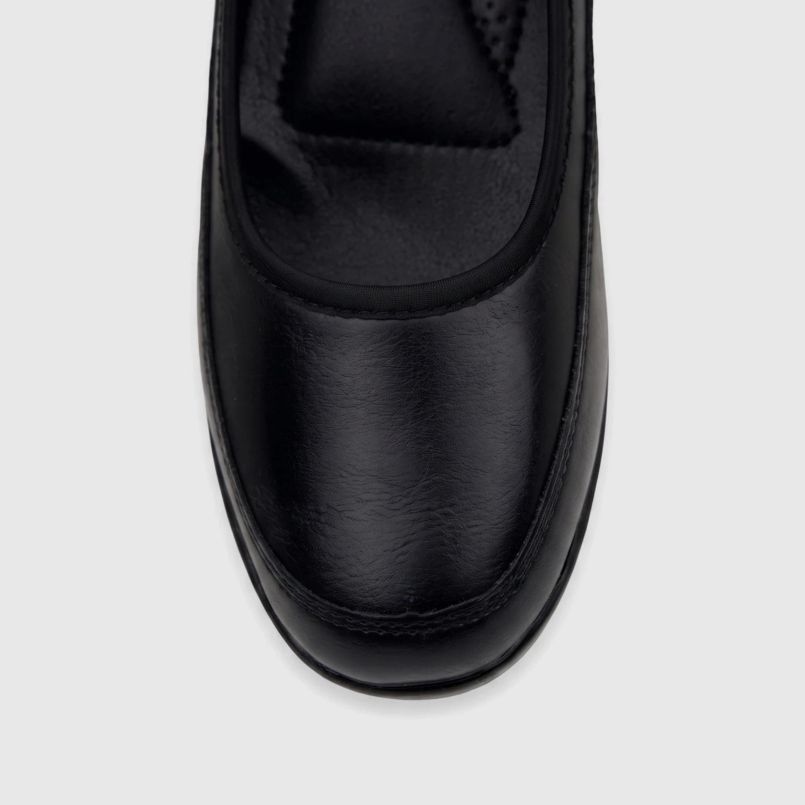 Close-up top view of a black leather PC Ladies Comfort Pump shoe, showcasing its smooth texture and stitching.