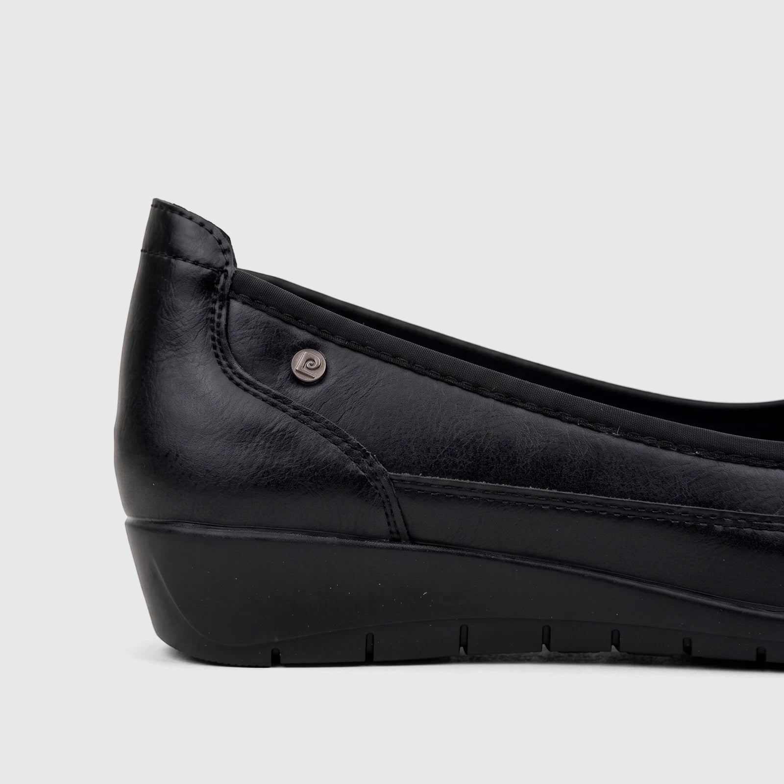 Side view of a black PC Ladies Comfort Pump shoe, featuring a textured upper, a low wedge heel, and a subtle logo detail.