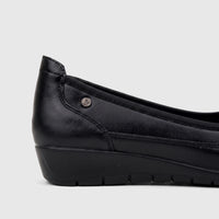 Side view of a black PC Ladies Comfort Pump shoe, featuring a textured upper, a low wedge heel, and a subtle logo detail.