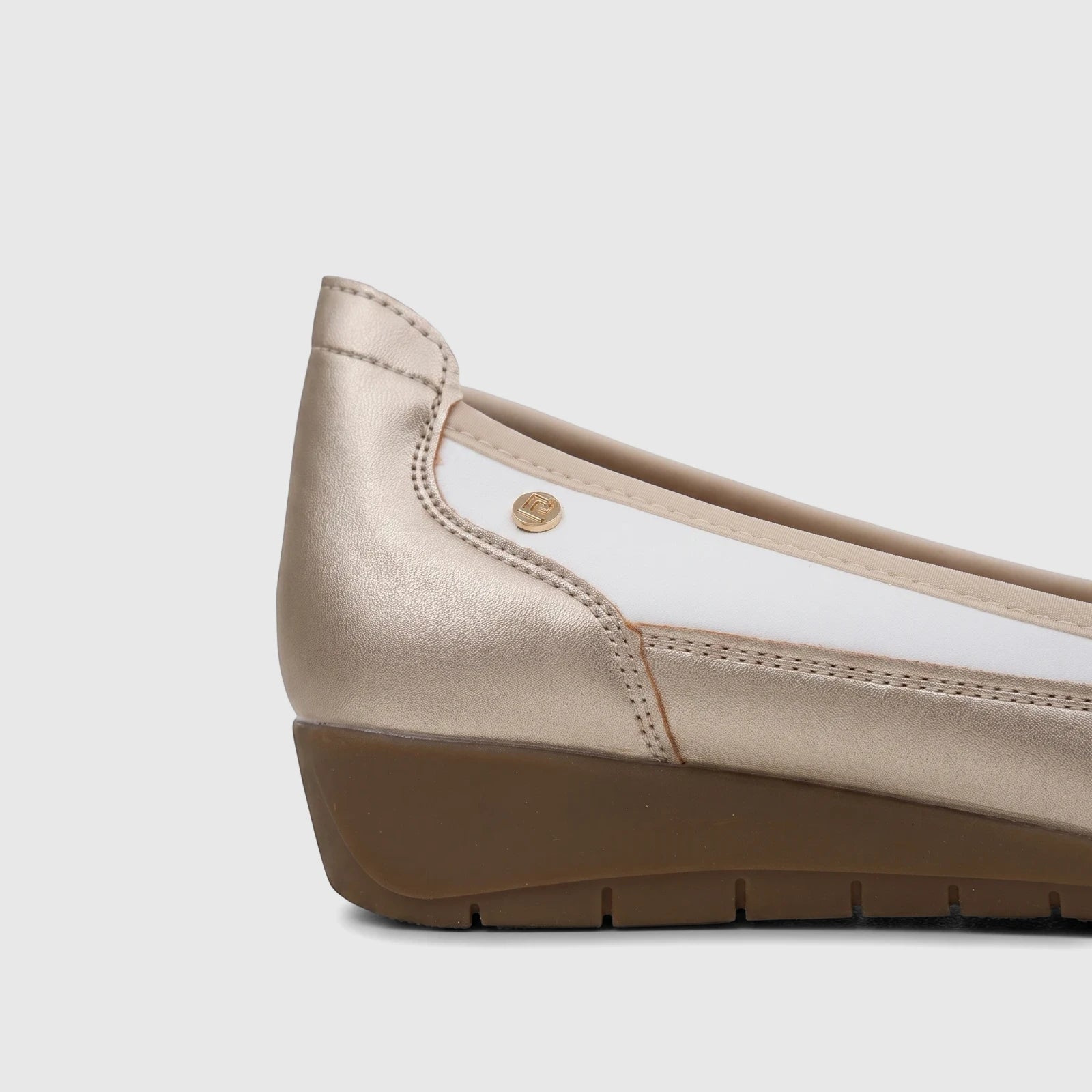 Side view of a PC Ladies Comfort Pump in white and metallic gold, featuring a wedge heel and detailed stitching.