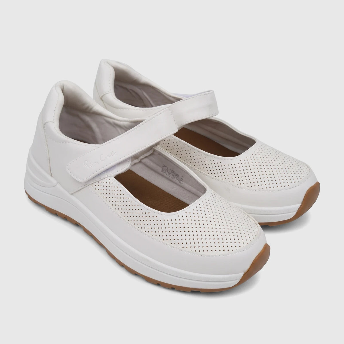 White PC Ladies Comfort Pump shoes, style PCL10986, featuring perforated details, a velcro strap, and a brown sole.