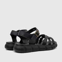 A pair of black PC Ladies Comfort Sandals PCL10974 from a side-back view, featuring textured straps, a brass buckle, and